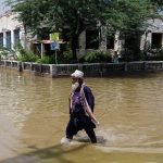 A man walks through rain waters, following rains and floods