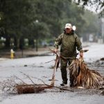 Residents clear debris from road as Ian bears down on