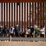 Asylum-seeking migrants are detained by a U.S. Border Patrol agent