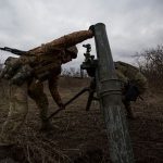 Ukrainian servicemen set up a mortar for firing it towards