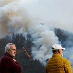 Locals observe a wildfire in Setienes