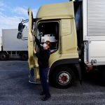 A truck driver Yuichi Tomita takes a break next to