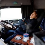 A truck driver Yuichi Tomita takes a break inside his