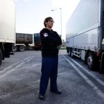 A truck driver Yuichi Tomita poses for a photograph next