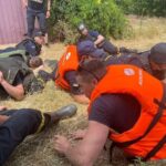 Emergency workers lay down during a Russian military in Kherson