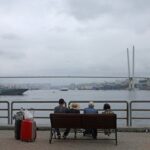 People sit on a bench on an embankment in Vladivostok
