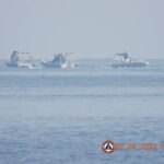 Chinese Coast Guard boats close to the floating barrier are