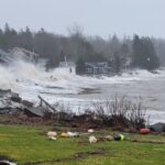 Water hits houses on a shore in Owls Head