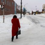 A woman walks down a street amid sub-zero temperatures, ahead