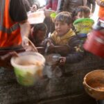Palestinians wait to receive food amid shortages of food supplies,