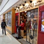 People walk past the Daryaganj restaurant at a mall in