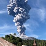 A column of ash rises over the Gunung Ibu volcano