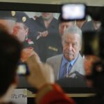 Journalists watch TV screen inside media tent as 73-year-old Austrian