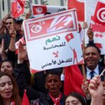 Supporters of Tunisian President Kais Saied carry flags and signs