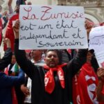 Supporters of Tunisian President Kais Saied carry flags and signs