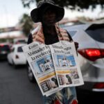 A man holds a newspaper a day after the general