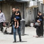 Palestinians walk, in Jenin