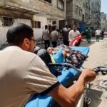Palestinians evacuate Kamal Adwan hospital following an Israeli strike, in