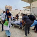 Palestinians evacuate Kamal Adwan hospital following an Israeli strike, in