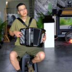 Artist Kacey Wong plays the accordion for the camera during