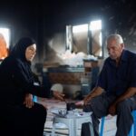 Palestinian couple Mahmoud and Fatima Jarghoun sit inside their damaged