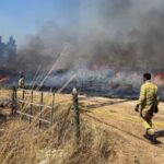 Israeli firefighters work following rocket attacks from Lebanon, amid ongoing