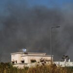 Smoke billows behind a house following over border attacks from