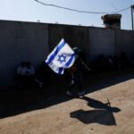 A demonstrator carries an Israeli flag during a protest against