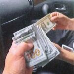 An undercover U.S. law enforcement officer is handed $15,000 in