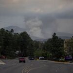 A plume of smoke rises from the South Fork fire