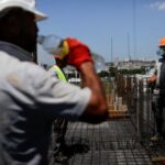 Construction workers work on a bulding during hot weather, in