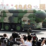 Military vehicles carrying DF-41 intercontinental ballistic missiles travel past Tiananmen