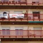 FILE PHOTO: A man ties protest banners in the balcony