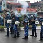 Riot police officers fire tear smoke shells to disperse demonstrators,