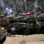 FILE PHOTO: An Israeli soldier walks near military vehicles, amid
