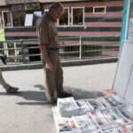 An Iranian man looks at a newspaper with a picture