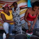 The Wider Image: Camping in schools, hungry Haiti families ask: