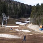 Melting snow and snow machines at a ski center in