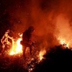 Firefighters tackle a blaze near the village of Piedrafita during