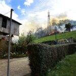 A homeowner observes firefighters tackling a blaze near the village