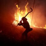 A firefighter from Galicia tackles a forest blaze near the