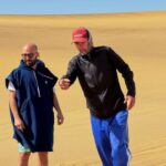Dune 7 sandboarding instructor Devon Waters talks with a tourist