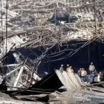 Members of the Russian Emergencies Ministry clear rubble at the