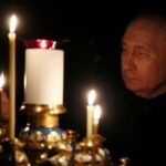 Russian President Putin lights a candle in memory of the