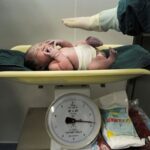 FILE PHOTO: A newborn baby is weighed after it was