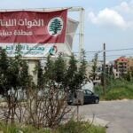 A car drives past a billboard in Byblos