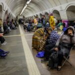 People take shelter inside a metro station during a Russian