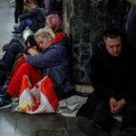 People take shelter inside a metro station during a Russian