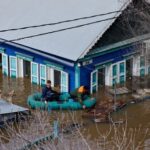 A man visits his flooded house every day to feed