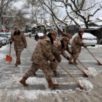 FILE PHOTO: Paramilitary police officers remove snow from a road